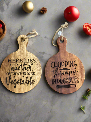 Two wooden cutting board-shaped ornaments with humorous inscriptions 