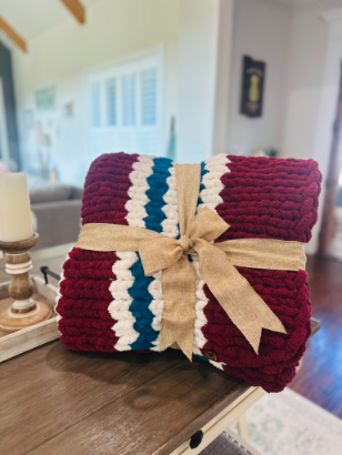 Knitted blanket with a bow on a wooden surface in a home setting
