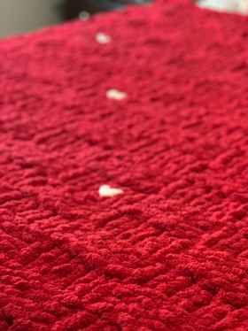 Close-up of a red blanket with little white hearts.